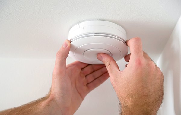 Man installing carbon monoxide detector