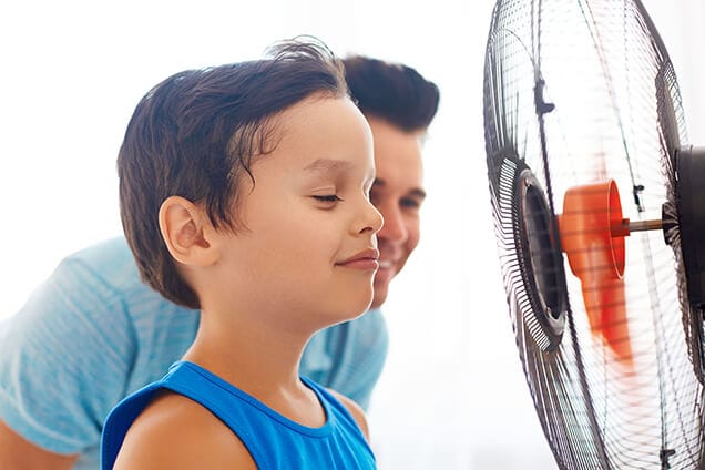 Boy cooling down by fan